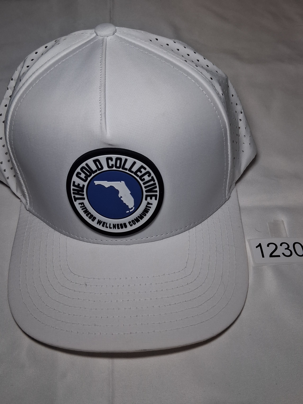 The Cold Collective White Trucker Hat with Blue Patch Logo
